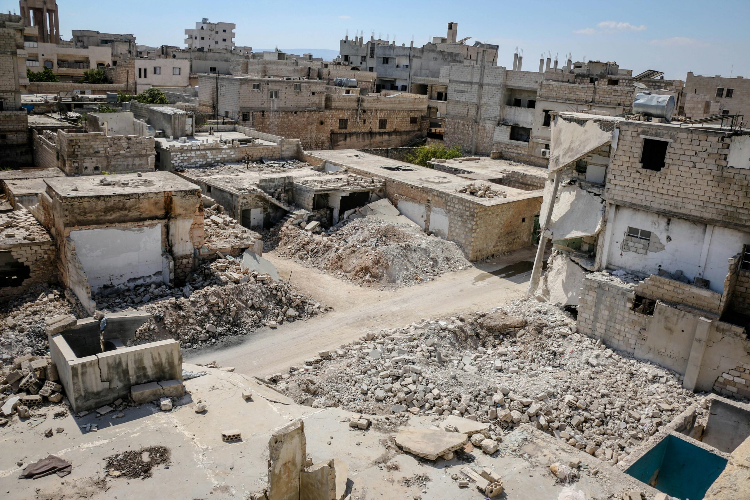 Aerial view of war-torn buildings and rubble in Idlib, Syria, highlighting urban destruction.