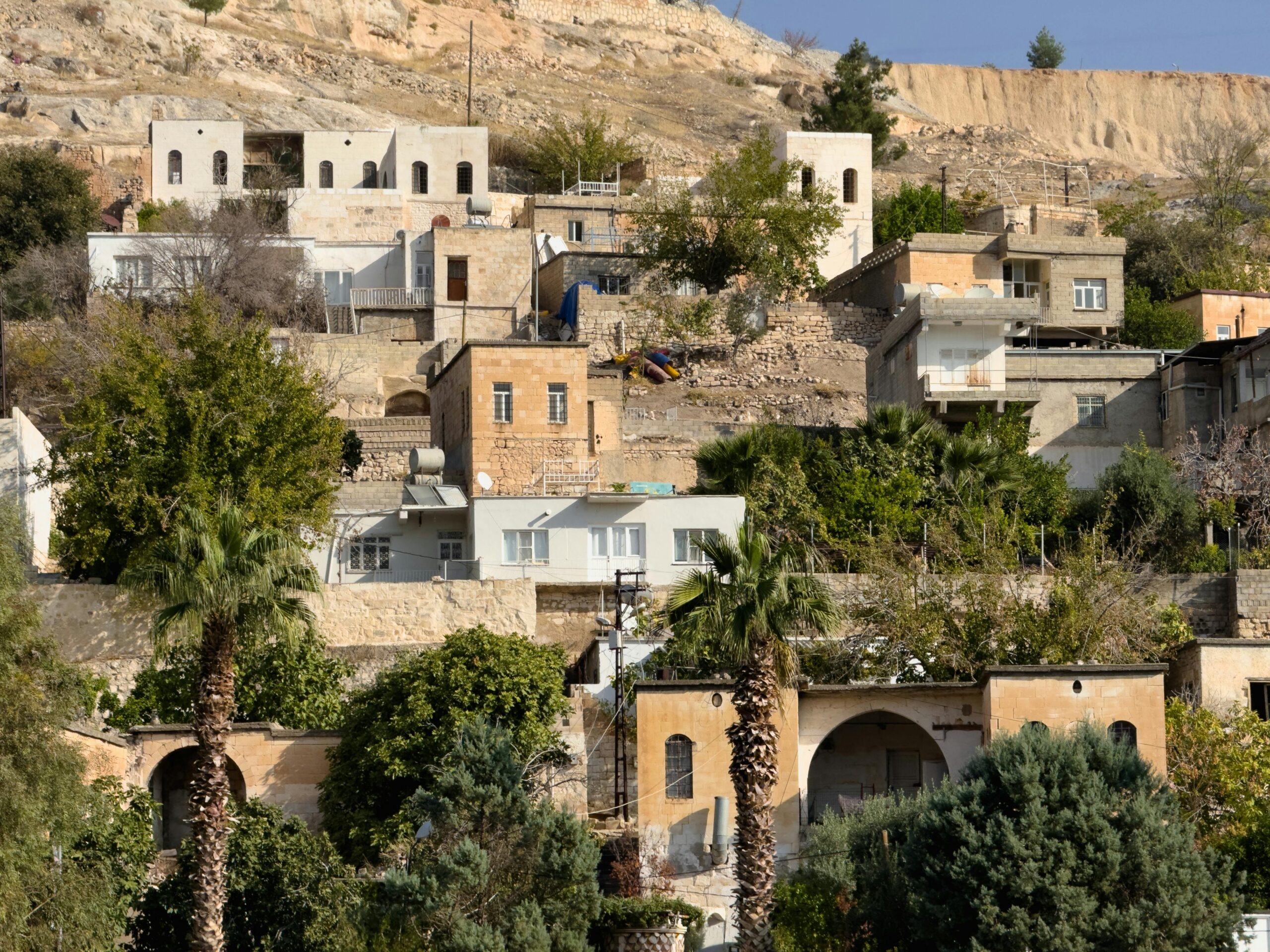 Charming hillside view of traditional houses in Şanlıurfa, Türkiye, capturing historical architecture.